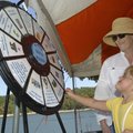 Deanna Fletcher with the Arkansas Master Naturalists helps Greta Cooper of Rogers spin a water trivi...