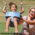 Anjel Foy, 2, gets swinging with a push from her grandmother, Lynn Troutner, at Lake Atalanta Park o...