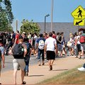 University of Arkansas students cross a busy pedestrian crossing at Dickson Street and McIlroy Avenu...
