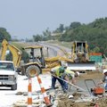 Workers smooth a freshly poured concrete sidewalk Tuesday as work continues to reroute South School ...