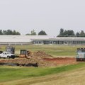 Construction crews work Tuesday to add space to the west side taxiway for airplanes to pull off and ...