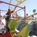 Richard Krause of Reed Exposition Midways in Paris, Texas, drives pins into dowels to secure the tra...