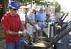 Clarence Guinn, left, fries hushpuppies Friday during the Rogers Rotary catfish fry at Frisco Festival in downtown Rogers. The event continues today with a variety of activities and entertainment.
