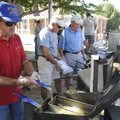 Clarence Guinn, left, fries hushpuppies Friday during the Rogers Rotary catfish fry at Frisco Festiv...
