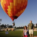 BALLOON RIDE - Ashley Schroeder, 4, walks with her father, John, right, after taking a ride in a hot...