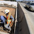 David Collins, left, and Filemon Medrano, both employees of Manhattan Road and Bridge, work on Wedne...