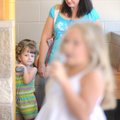 Audrey Hill, 3, left, watches as older contestants practice Saturday alongside her mother, Pam Hill,...