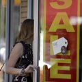In this photo taken Aug. 26, 2010, a woman walks into a clothing store advertising a sale in St. Lou...