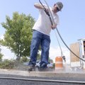 Roy Stanphill with Danny Robinson Contruction prepares a sidewalk for sealing Monday along Northeast...