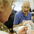 Roy Hemminger of Rogers plays pinochle Monday with Eva Duffy of Farmington at the Rogers Adult Welln...