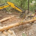 Jon Bryan with help from track hoe operator Chris Crone set logs Tuesday in the construction of one ...