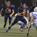 Rogers Heritage freshman Brandon Gates cuts through the Rogers High defense on his way to the end zo...