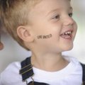 Brett Williams, 2, smiles Wednesday as he is held by his mother, Allison Williams of Lowell, while w...