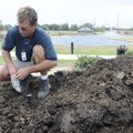 Tim Perkins with Bentonville’s Parks and Recreation Department installs sprinkler heads Wednesday at...