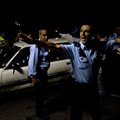 Israeli policemen secure the site of a shooting attack near the Jewish settlement of Kiryat Arbah, T...
