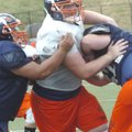 Rogers Heritage’s Reid Schatzman muscles his way through the War Eagles’ offensive line during pract...