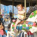 RIDE OF YOUR LIFE - Blakely Stonesifer, 2, laughs Thursday while taking a ride on the merry-go-round...