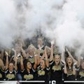 Bentonville High School students toss baby powder into the air as their team takes the field Friday ...
