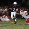 Huntsville sophomore running back Brandon McRae slips past Farmington senior Benton Cooper, left, an...