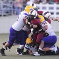Springdale High’s Lentonio Jenner is brought down by Little Rock Catholic’s Hayden Carmen, left, and...