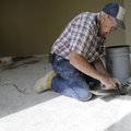 Lowell Prine with Clear Energy fills in some concrete divots Wednesday in the floor of a room inside...