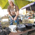 Nancy Kirkner of West Fork loads charcoal Saturday onto the top of her Dutch oven while competing in...