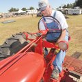 Ronnie Cummins of Inola, Okla., starts his 1952 Farmall M tractor Saturday while preparing to take p...