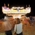 People wait in line Friday to ride Himalaya, a ride featured in the midway provided by Reed Expositi...
