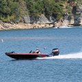 A fisherman skirts a buoy-marked shoal while two personal water craft riders approach it Sunday on t...