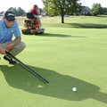 Bart Bellmon, assistant golf superintendent, uses a Stimpmeter to measure the speed of a green at Pi...