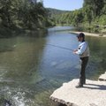 Russ Tonkinson of Rogers fishes from a low-water bridge on Big Sugar Creek before float-fishing abou...