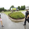 Dustin Johnson, a patrolman for the Rogers Police Department, right, stops traffic as Amy Hung, prof...