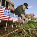 Jim Huddleston, shift engineer for the Cosmopolitan Hotel, lines the sidewalk with flags Friday. Hud...