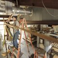 Justin Comins, maintenance worker, left, and Duane Dunn, longtime glassworker and artist, install li...