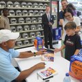 Tyler Goldstein, 8, from Bentonville gets a photograph signed by former National Basketball Associat...