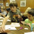 Landon Wooldridge, 8, left, and Tyler Cawein, 8, glue pieces of a paper covered wagon Tuesday at the...