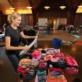 SORTING IT OUT - Volunteer Laura Marble of Fayetteville sorts and prices clothing Friday while prepa...