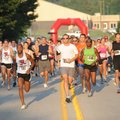 GOING THE DISTANCE - Runners make their way Saturday along Leroy Pond Drive in Fayetteville while pa...