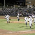 Players rush the pitching mound after the win.
