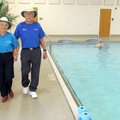 Jan Muetzel and husband Dean Muetzel walk Friday beside the indoor pool at the Rogers Adult Wellness...