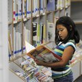 Stephanie Barnes, 9, reads a book Monday in the children’s center at the Rogers Public Library.