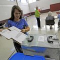Lynn Branham of Springdale drops her ballot Tuesday while voting at the Springdale Youth Center. Vot...