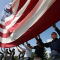 Oscar Meza of Springdale (right) joins other citizenship candidates to raise the American flag up th...