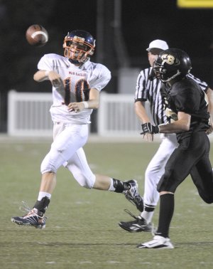 Rogers Heritage freshman quarterback Josh Qualls throws a pass Sept. 9 while being pressured by the Bentonville Black defense in Tiger Stadium in Bentonville.