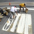 Chris West, left, and Brad Cordell with Marking Systems paint the street Thursday at Poplar and Seco...