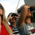 Arkansas alumni Ashley Meek (left) and Stephanie Woodruff, both of Fayetteville, watch from the nort...