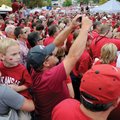 Becka Pilkinton, bottom left, helps her nephew Ethan Dickerson, 5, up to see the Razorback football ...
