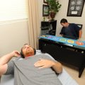 Client Matt Courtney of Fayetteville settles in for a half-hour session as E.D. Laningham prepares h...