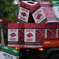  Kevin Jones, with the University of Arkansas Athletic Department, picks up waste containers Sunday ...