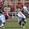  University of Arkansas defender Elton Ford pulls down Alabama running back Mark Ingram in the secon...